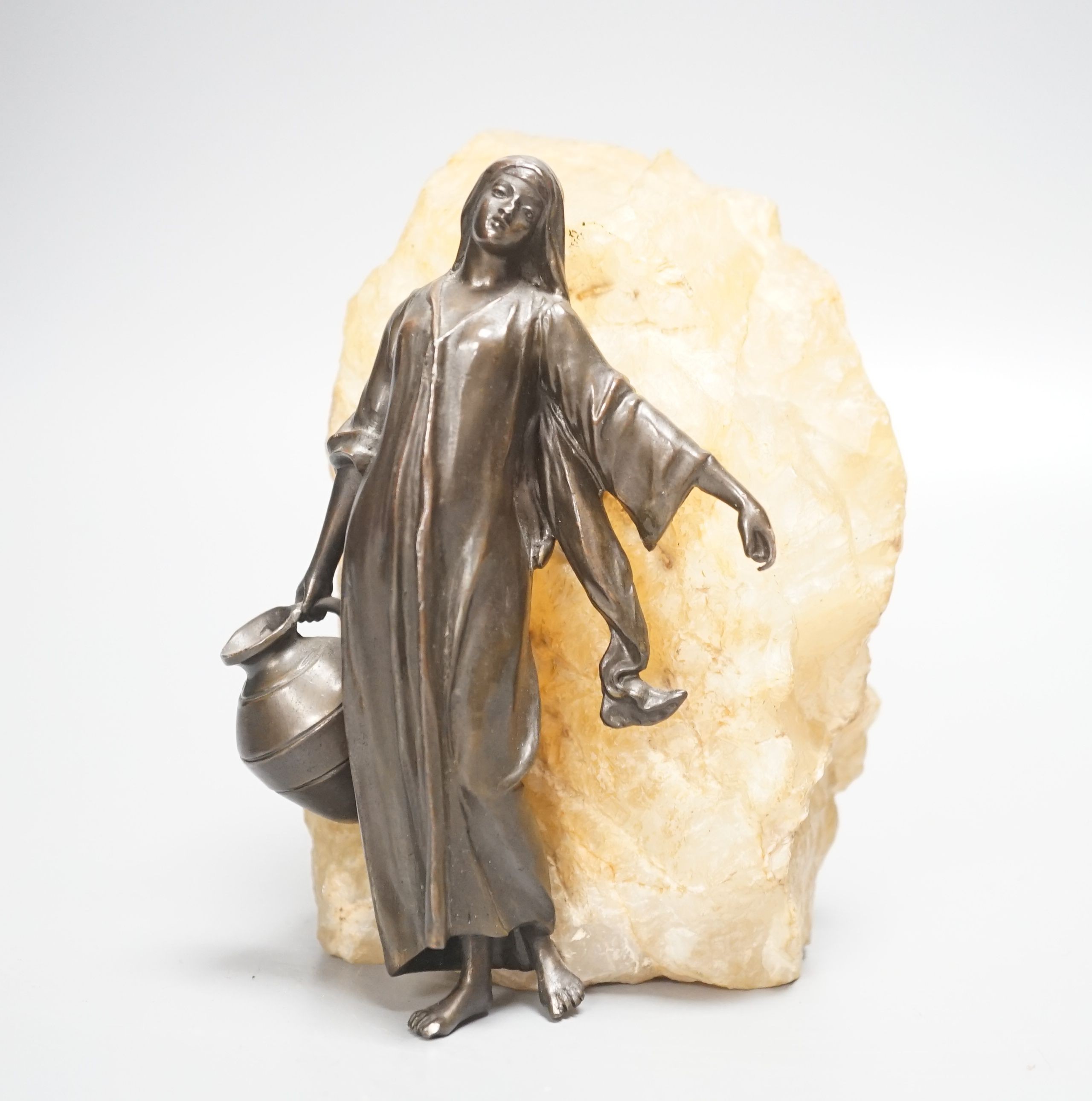 An early 20th century patinated spelter figure of a water carrier, mounted on quartz 16cm